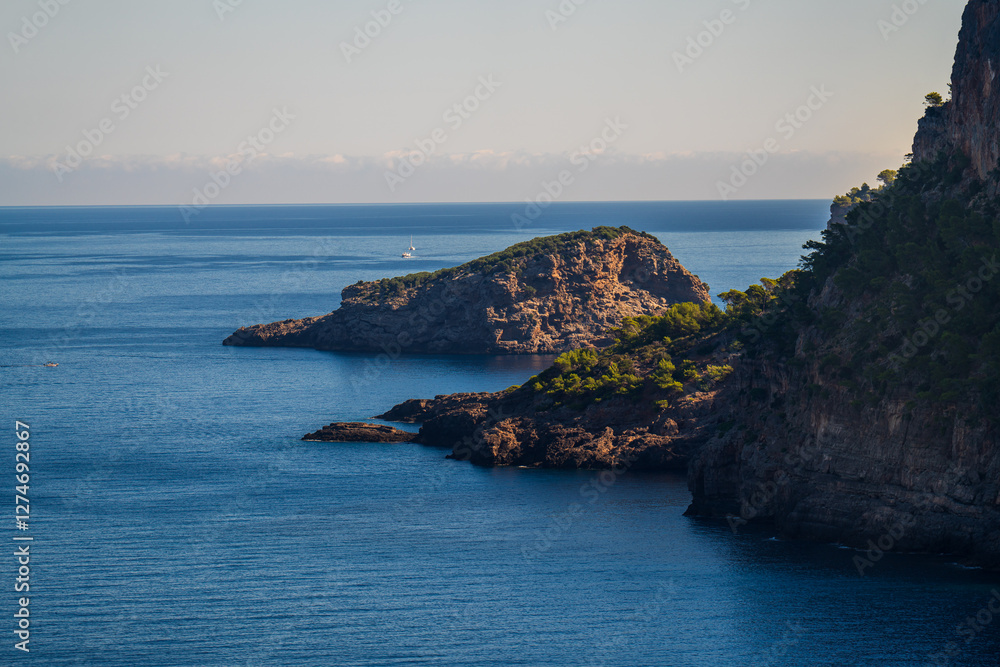 Yacht floats on crystal clear waters near rugged rocky coastline of Port de Soller. Stunning Mediterranean seascape with serene, luxurious atmosphere. Mallorca, Balearic Islands Yacht floats on crystal clear waters near rugged rocky coastline of Port de Soller. Stunning Mediterranean seascape with serene, luxurious atmosphere. Mallorca, Balearic Islands