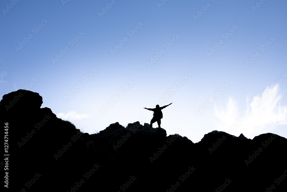 Man climbs to the summit feeling fearless, courageous, determined, empowered Man climbs to the summit feeling fearless, courageous, determined, empowered