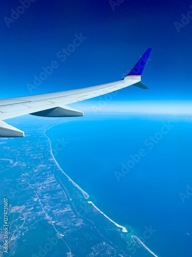 View from the airplane window on a beautiful sky and the wing of the airplane. Earth and sky as seen through an airplane window