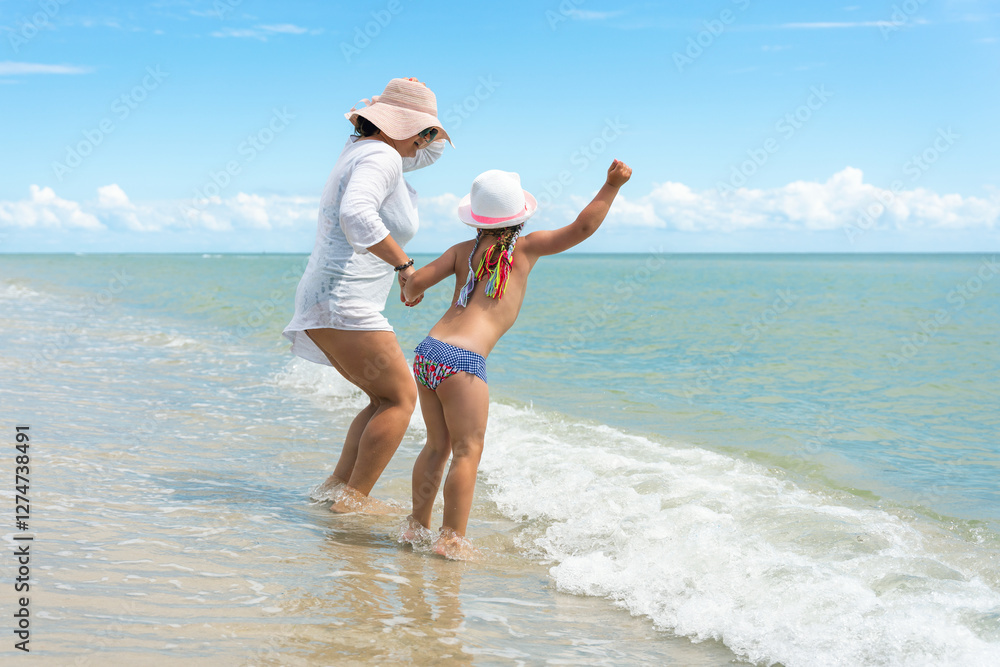 Mother and daughter jumping over the waves at sea. Family summer vacation at sea Mother and daughter jumping over the waves at sea. Family summer vacation at sea