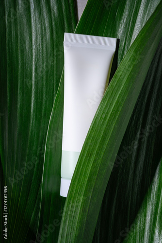 Cosmetic tube on lush green leaves highlighting eco-friendly product photo