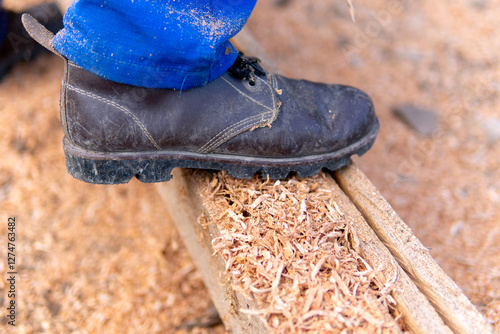 Man's boot on a sawn log during farm work in Colombia