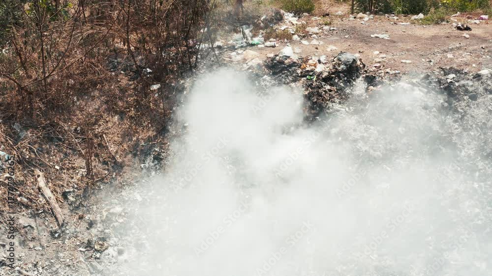 Garbage, fire burning and smoke in landfill. Also called trash, waste ...