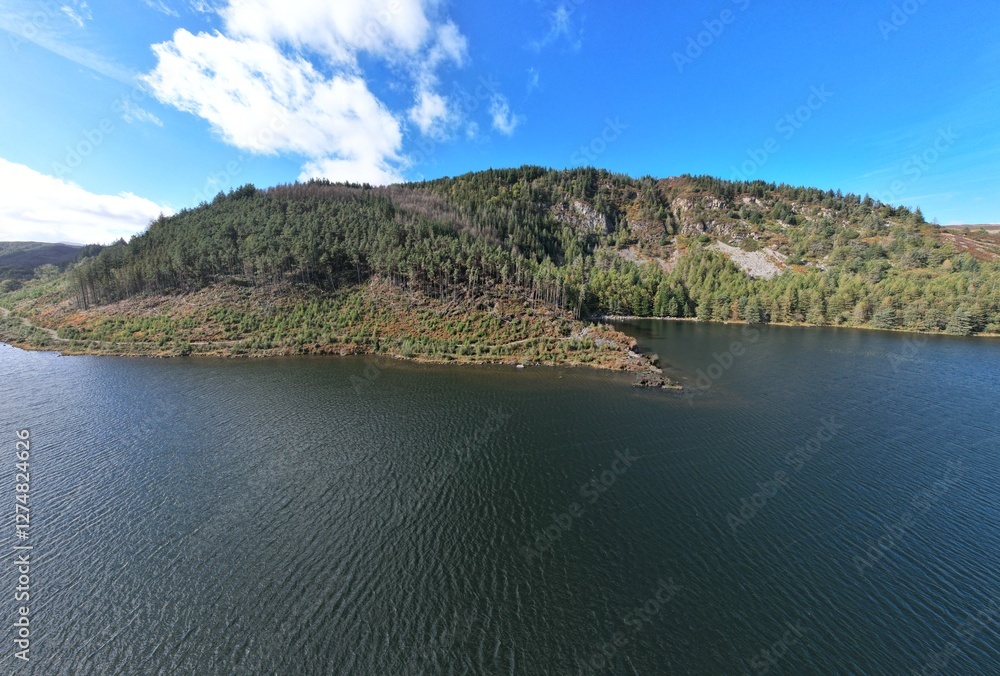 Obraz premium Llyn Geirionydd lies in a valley in North Wales where the northern edge of the Gwydyr Forest meets the lower slopes of the Carneddau mountains. The lake is almost a mile long.