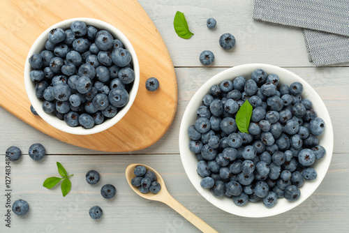 Bowl with fresh bright blueberries on wooden background,top view photo