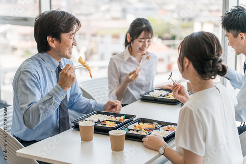 Foto 社員食堂でランチ・仕出し弁当・デリバリー・ケータリングの弁当を食べる男女（福利厚生）