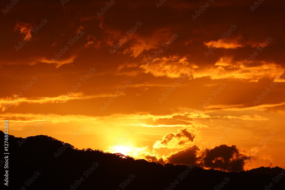 Golden hour sunset over a silhouetted mountain Golden hour sunset over a silhouetted mountain