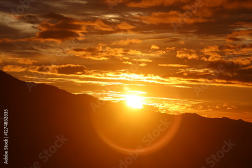 Golden hour sunset over silhouetted mountains