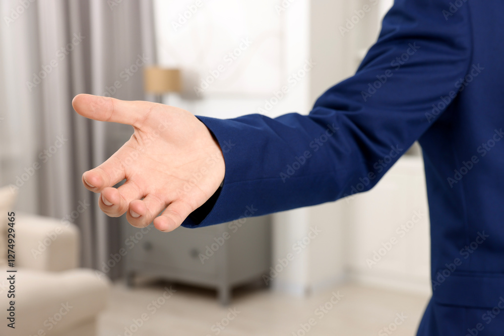 Offering help. Man reaching his hand indoors, closeup Offering help. Man reaching his hand indoors, closeup