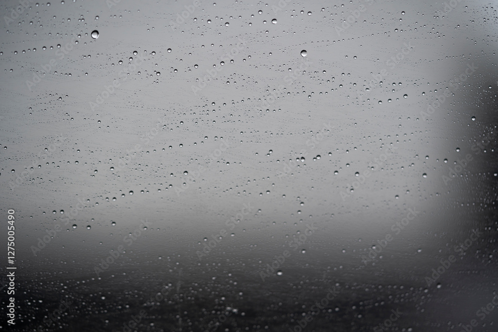gotas de lluvia sobre vidrio de ventana de coche con fondo desenfocado de cielo gris gotas de lluvia sobre vidrio de ventana de coche con fondo desenfocado de cielo gris