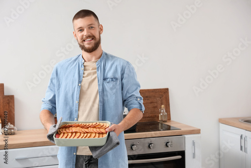 Young man holding baking di...