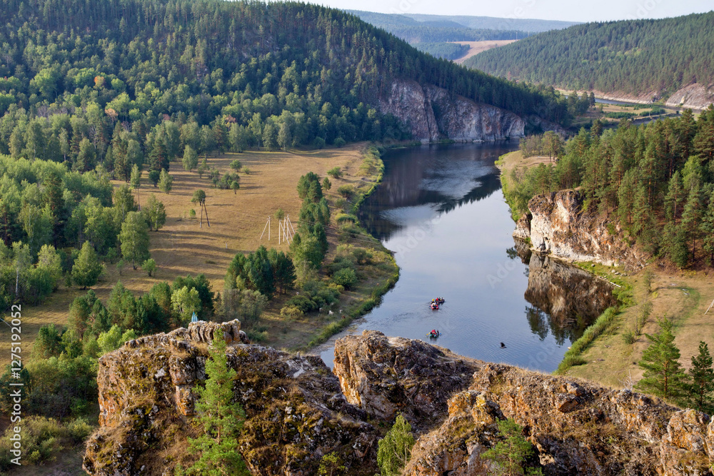 Obraz premium picturesque view of the Belaya River, the South Ural taiga, tourists rafting from the Insebika cliff on a summer day