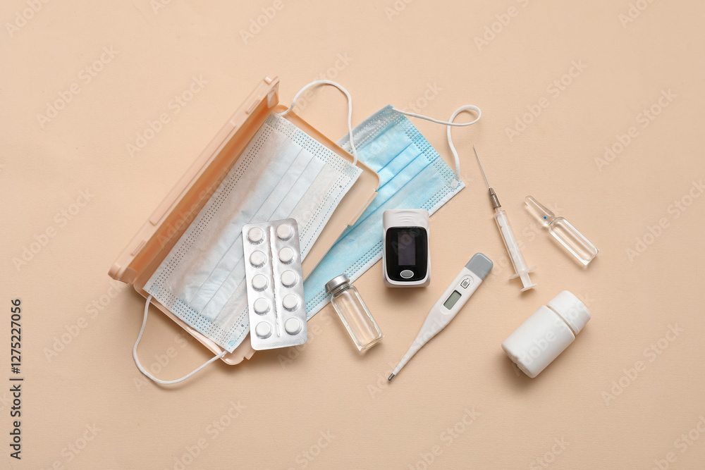 Composition with pulse oximeter, thermometer, medical masks and medicines on beige background Composition with pulse oximeter, thermometer, medical masks and medicines on beige background