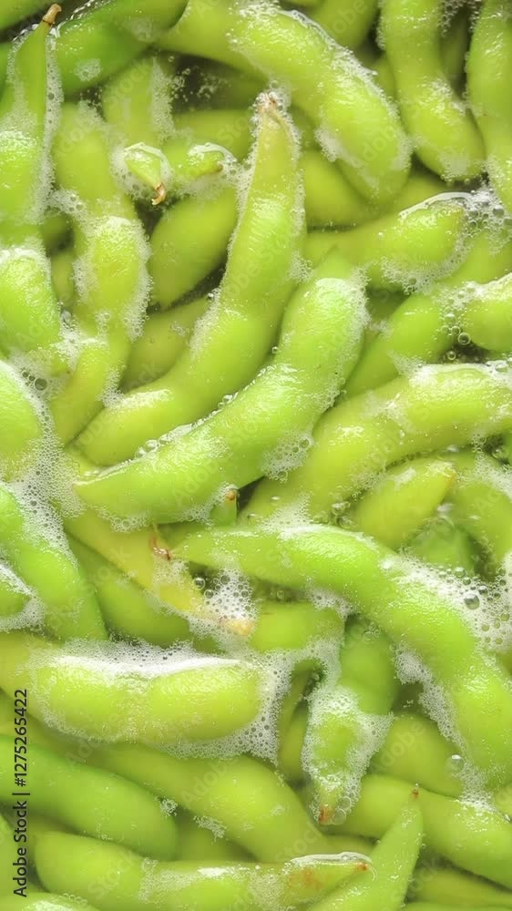 Boiled green soybeans or edamame in boiling water. Top view Boiled green soybeans or edamame in boiling water. Top view