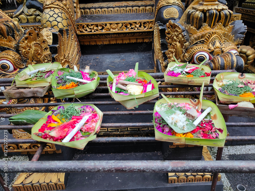 Traditional balinese offerings to gods in Bali with flowers and aromatic sticks