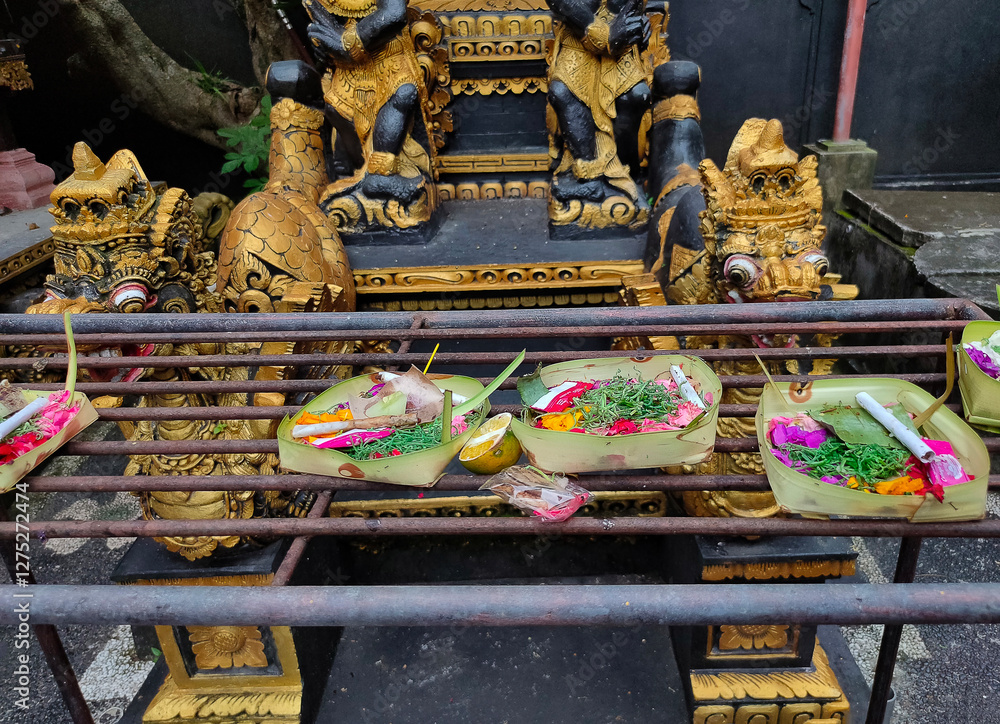 Traditional balinese offerings to gods in Bali with flowers and aromatic sticks