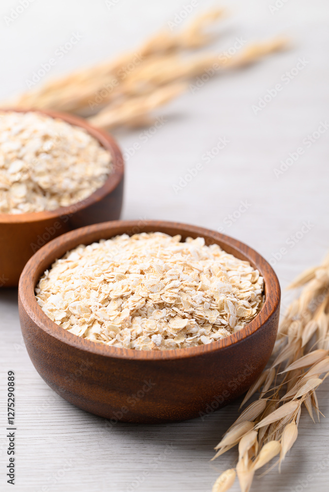 Oat flakes in wooden bowl, Food ingredient in oatmeal, muesli or porridge Oat flakes in wooden bowl, Food ingredient in oatmeal, muesli or porridge