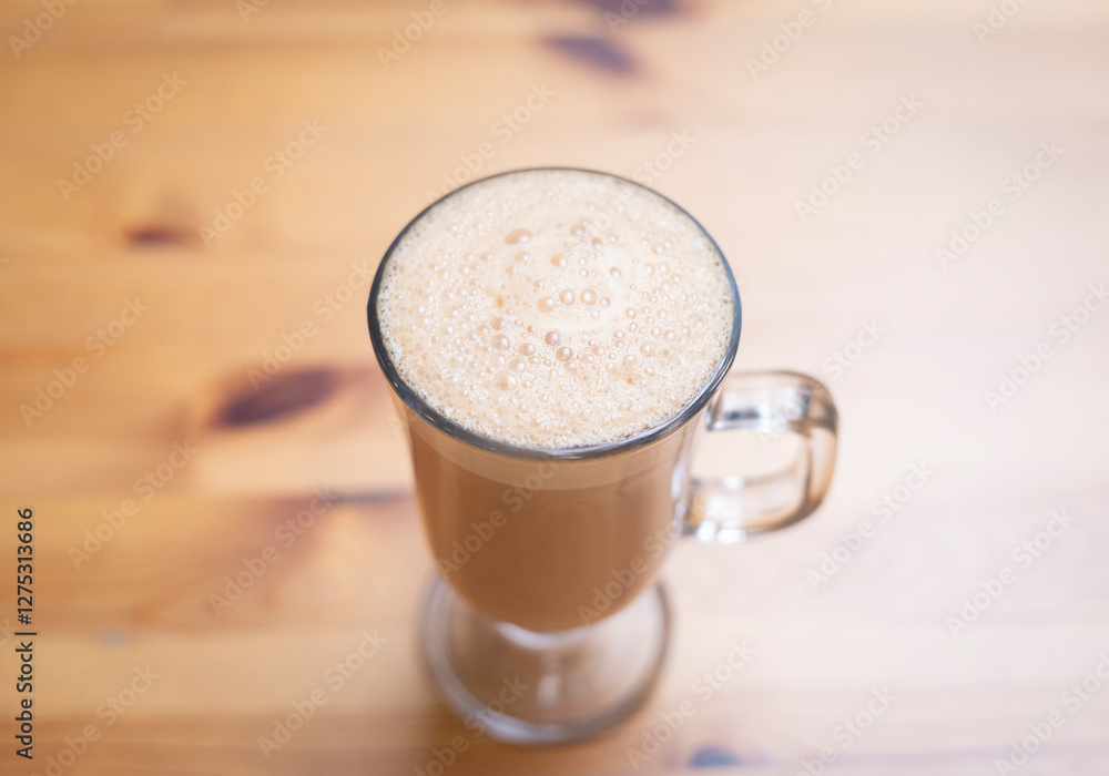 Thai tea in glass milk hot water breakfast background show wood table top with food art, cup of coffee milky latte foam leaf, as drink isolated on a light cozy christmas bar.
