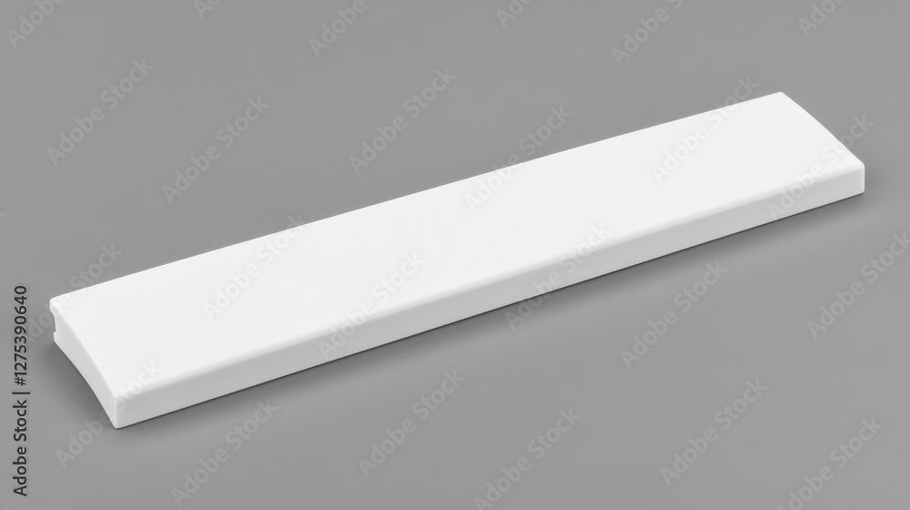 White rectangular plastic part isolated on gray background. White rectangular plastic part isolated on gray background.