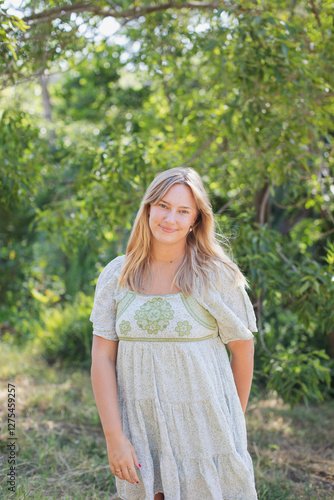 Girl in Sundress Walking in a green forest photo