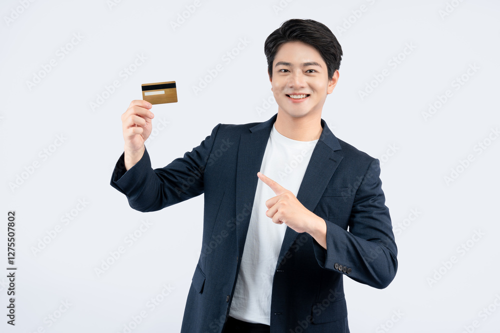 Portrait of young Asian business man holding bank card and posing on white background Portrait of young Asian business man holding bank card and posing on white background