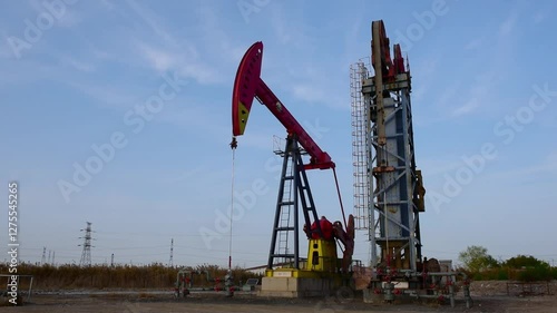 Against the backdrop of blue sky and white clouds, a pumping unit in a certain oil field is producing oil
