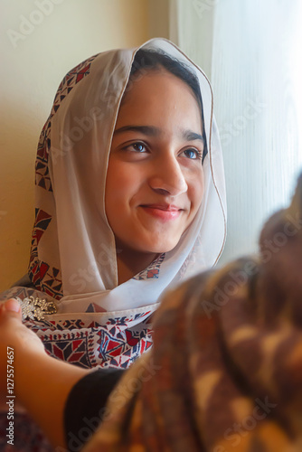 Muslim girl in a hijab smiling as her mother photo