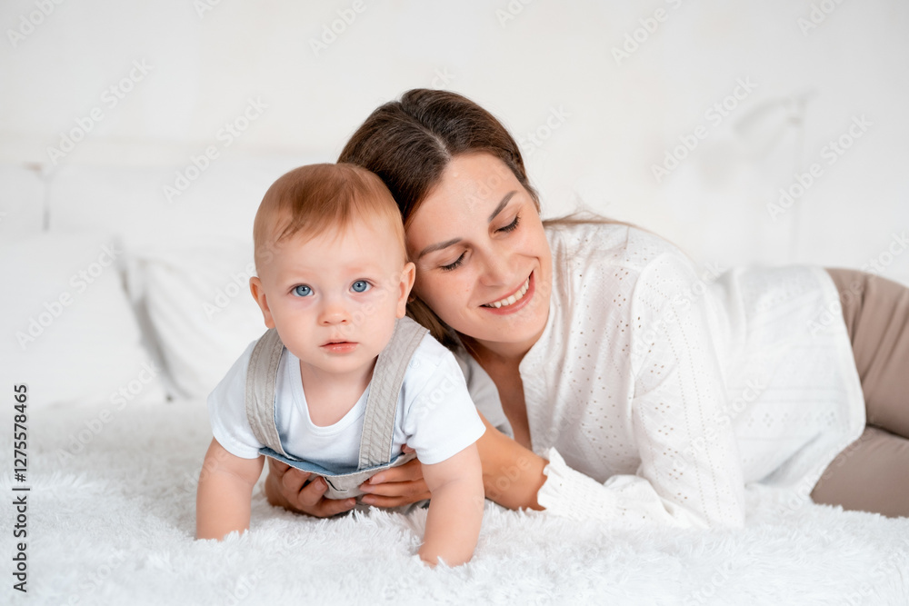 mom with baby, young mom gently hugs and kisses her baby son at home on the bed, maternal love and care, happy decree, mother and little baby boy mom with baby, young mom gently hugs and kisses her baby son at home on the bed, maternal love and care, happy decree, mother and little baby boy