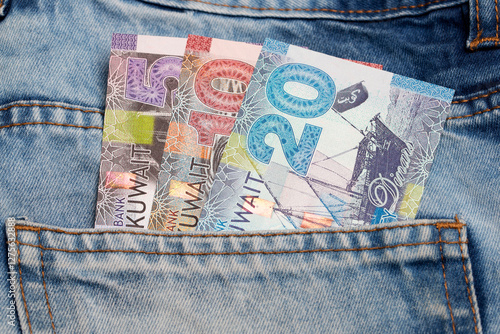 Kuwaiti dinar in the pocket of blue jeans