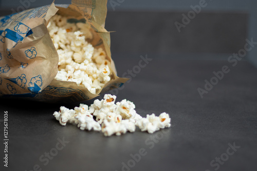 Fresh popcorn in bag made in a microwave on grey kitchen table