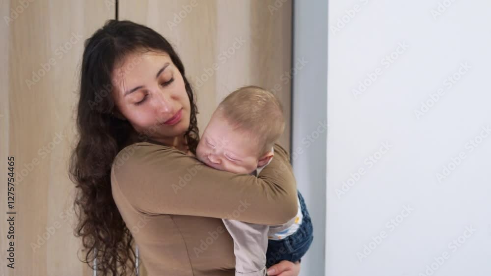 Latin Mother gently holding her sleeping baby Latin Mother gently holding her sleeping baby