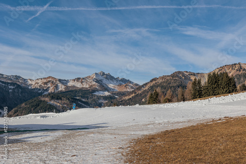 Obraz na płótnie panoramica su un ambiente naturale tra le montagne del nord Italia, parzialmente innevato, di giorno, in inverno, con cielo sereno, leggermente nuvoloso w salonie