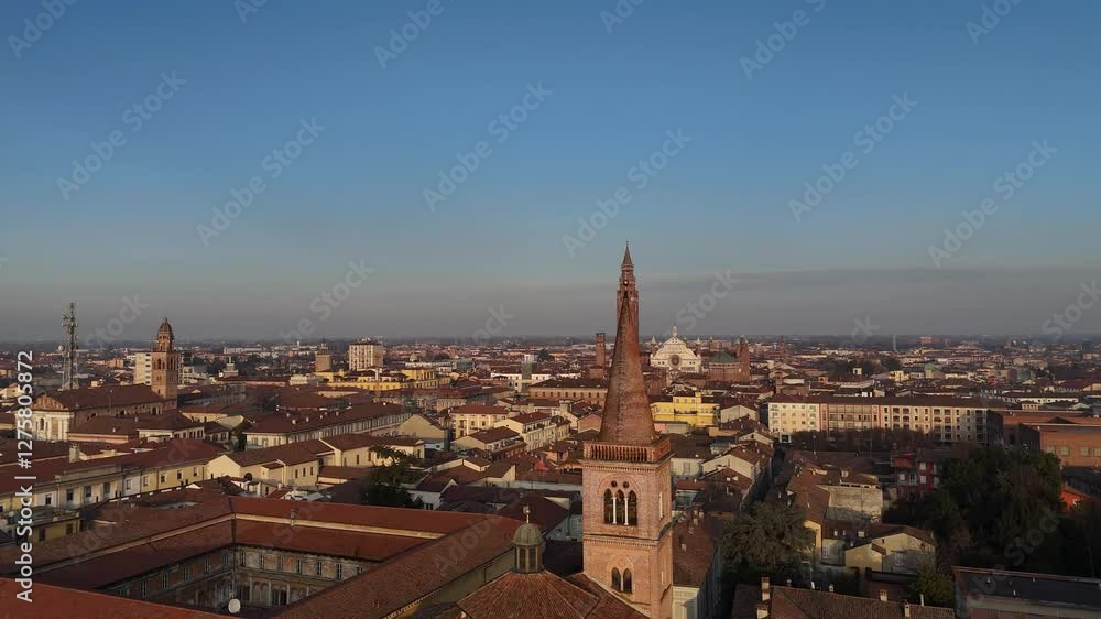 Aerial view capturing Cremona's skyline with the iconic Torrazzo, red-tiled roofs, and San Pietro bell tower near historic buildings glowing in the warm sunset of a clear winter day Aerial view capturing Cremona's skyline with the iconic Torrazzo, red-tiled roofs, and San Pietro bell tower near historic buildings glowing in the warm sunset of a clear winter day