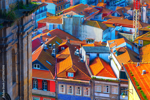 Obraz na płótnie Vibrant rooftops of European city with colorful facades and terracotta tiles under sunlight. Mix of traditional and modern architecture creates picturesque urban landscape full of charm and character w salonie
