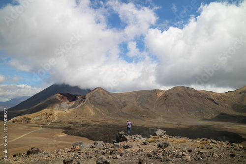 Fotografie Hikers making their way up a volcanic ridge in New Zealand, surrounded by steaming crater rocks and breathtaking views