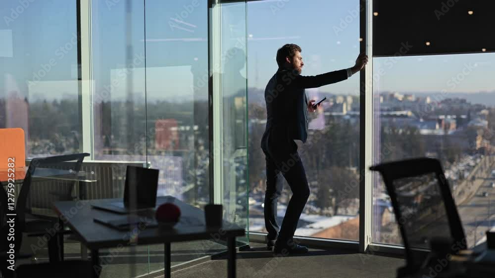 Confident businessman using phone in modern office with cityscape view. Young professional enjoys success, ambition, and leadership in corporate world. Confident businessman using phone in modern office with cityscape view. Young professional enjoys success, ambition, and leadership in corporate world.