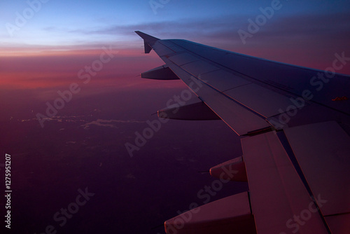 Flug bei Sonnenuntergang – Magische Farben über der Erde. Faszinierende Luftaufnahme aus einem Flugzeug während des Sonnenuntergangs. Die Bilder zeigen einen atemberaubenden Blick aus dem Fenster.