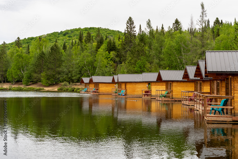 Naklejka premium Wooden small cottages for camping on the shore of a forest lake, Quebec, Canada