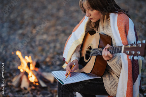 Quadro su tela Girl composer playing the guitar on campsite near the bonfire