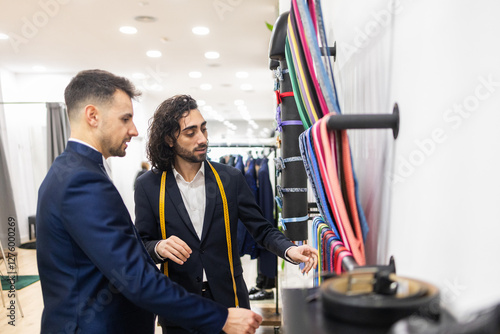 Tailor assisting client with suit selection in a suit store