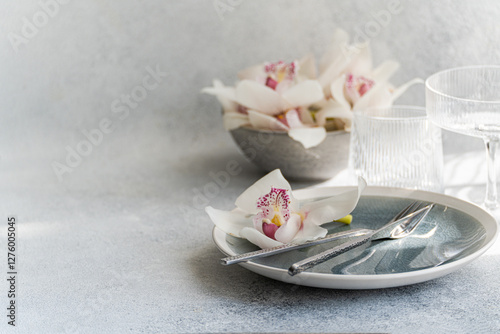 Elegant Table Setting with Orchids and Modern Dishware photo