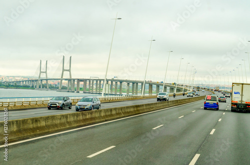 Wallpaper Mural Lisbon, Portugal - October 31, 2024: Traffic on The Vasco da Gama Bridge (Portuguese: Ponte Vasco da Gama) is a cable-stayed bridge in a rainy day. Torontodigital.ca