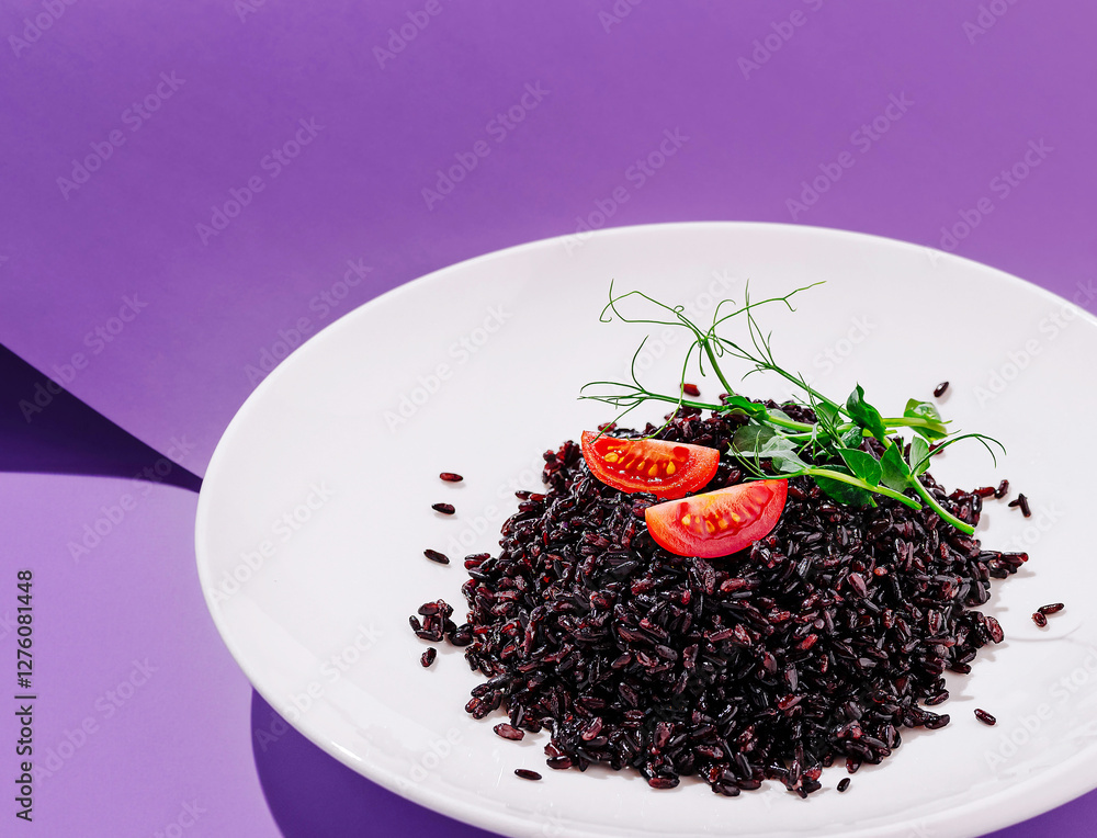 Serving of black rice with fresh tomatoes and greens on display Serving of black rice with fresh tomatoes and greens on display
