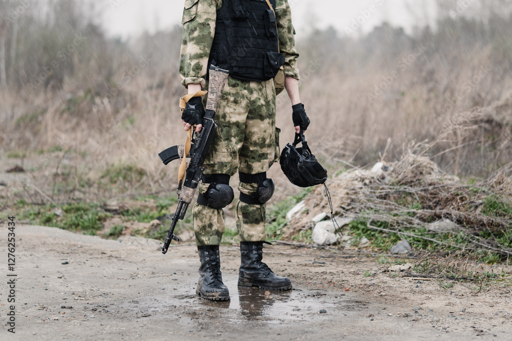 Obraz premium Professional marine soldiers training with weapon on military range. special forces soldier with a Kalashnikov assault rifle and helmet in his hands after training or combat.