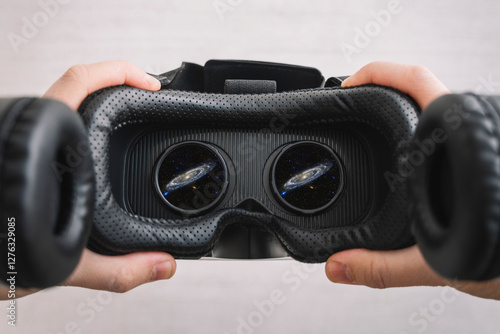 Obraz na płótnie a man watching a video in virtual reality glasses. People and technology metaverse concept. 360 degree video viewing. outer space with vr glasses. Used a photo from the NASA collection w salonie
