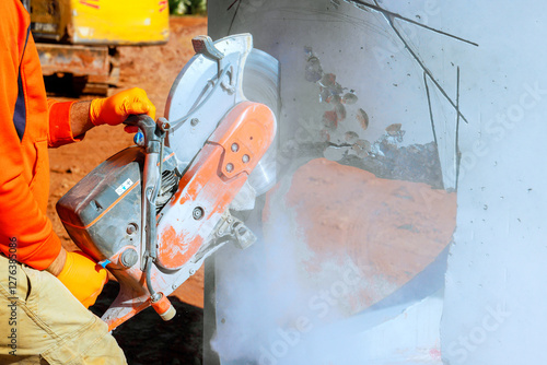 Canvas-taulu Worker uses concrete cutter, shaping drainage system creating dust on constructi