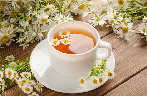 Wallpaper Mural Chamomile tea in a white cup on a wooden background with a bouquet of daisies with selective focus Torontodigital.ca