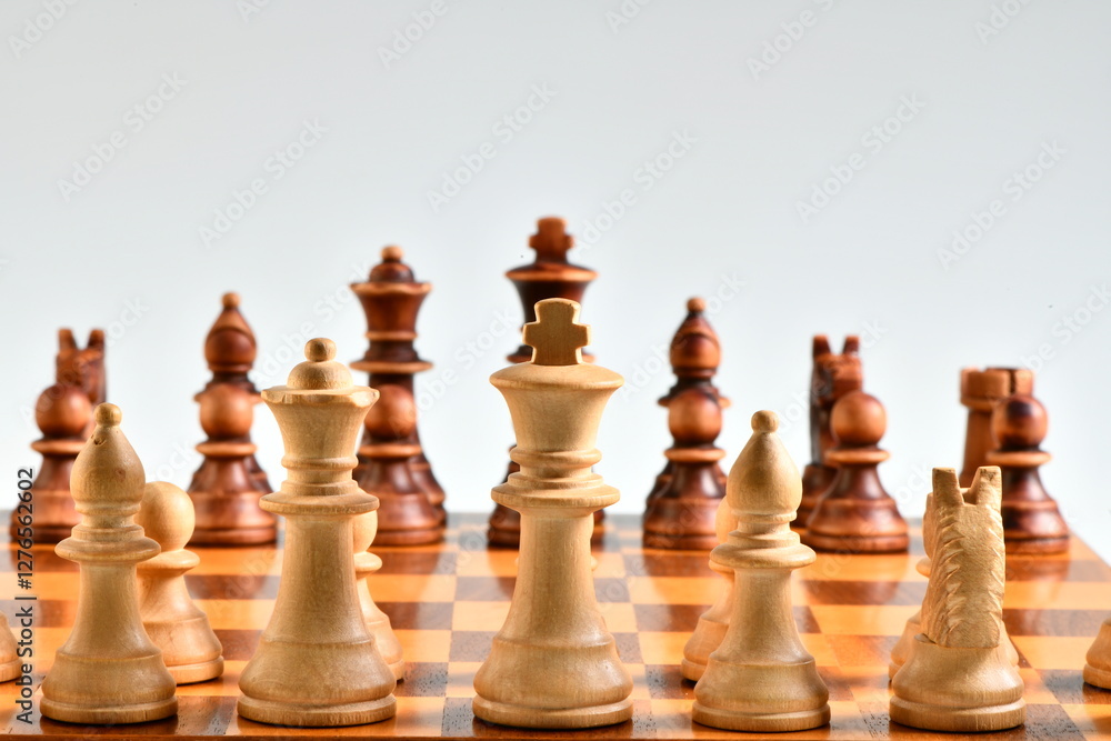 Chess game concept: The chess pieces placed on the chessboard isolated on white background Chess game concept: The chess pieces placed on the chessboard isolated on white background