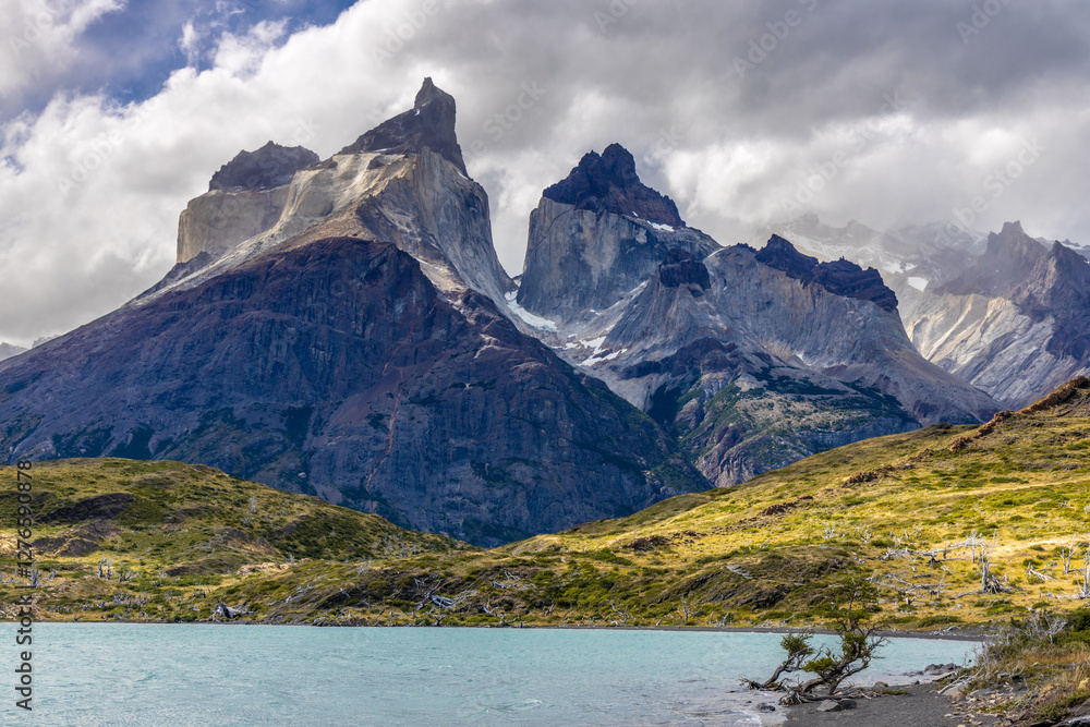 Torres del Paine national park mountain landscape in Patagonia, Chile. Los Cuernos and Torres del Paine peak granite towering summits on a nasty and sunny day above the blue water lake in the Andes Torres del Paine national park mountain landscape in Patagonia, Chile. Los Cuernos and Torres del Paine peak granite towering summits on a nasty and sunny day above the blue water lake in the Andes