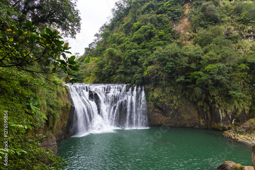 Misty Shifen waterfall cascading through Taiwan forest